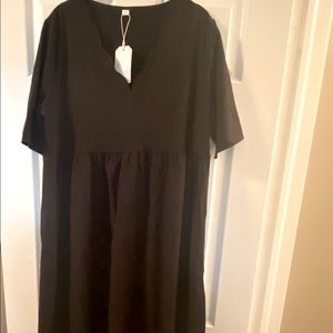 Women’s black short sleeve midi dress with pockets and scallop neckline.